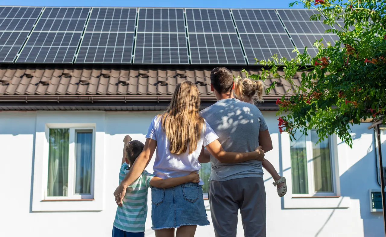 Zufriedene Familie vor ihrem Eigenheim mit ewerke-Energiesystem